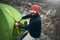 Overhead shot of traveler man with beard pitch tent camping gear outdoor in mountain. Male hiking in moutain. Travel, lifestyle