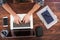 Overhead shot of white mans hands typing on a laptop