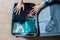 the overhead top view of person packing the bag with his personal things on the wooden florr at home