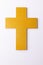Overhead vertical image of yellow christian cross, on white background with copy space
