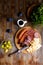 Overhead view of aperitif table Meat snack, fried sausages, cheese, salami, olives and a glass of wine on a dark table Menu and re