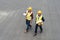 overhead view of architects in safety vests and hardhats with blueprints