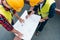 overhead view of architects in safety vests and helmets drawing