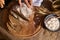 Overhead view of a baker slicing whole grain bread on a cutting board with a kitchen knife.