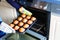 Overhead view of a baking tray with freshly prepared plain chocolate vanilla muffins holding by a child