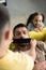 overhead view of children closing father mouth with black tape