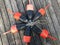 An overhead view of a circle of red and black lobster buoys tied together with rope on a dock in Maine, USA