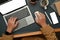 Overhead view of creative man typing email, searching information on laptop computer