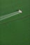 An overhead view of a crop duster spraying green farmland