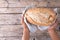 Overhead view of cropped african american male hands holding baked bread loaf over table