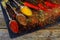 Overhead view depicting cooking with spices in a rustic kitchen with bowls of colourful ground spice and scattered powder on an ol