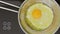 Overhead view of an egg frying in a pan. With zoom in.