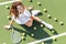 overhead view of fashionable tennis player in white sportswear and sunglasses resting on tennis court with balls and racket