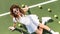 overhead view of fashionable tennis player in white sportswear and sunglasses resting on tennis court with balls and racket