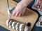 Overhead View Female Hands Cut German Marzipan Stollen With Knife On Wooden Board