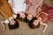 Overhead view of four little girls lying on the floor head to head