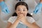 Overhead view of girl covering mouth with hands sitting in dental chair