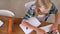 Overhead View Of Girl Doing Homework At Table On Laptop