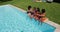 Overhead view of group of diverse girls eating watermelon while sitting by the pool