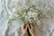 Overhead view of hands holding a bunch of white gypsophila flowers