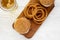 Overhead view, homemade Mississippi Slug Burgers with onion rings and glass of cold beer on a white wooden surface. Flat lay, from