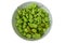 Overhead view of lots of green Capsicum Chinense chili pepper pods in large ceramic bowl