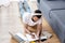 Overhead view of man in headphones writing on notebook during webinar near laptop on floor