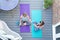 Overhead View Of Mother And Daughter Giving Each Other Cheers With Water Bottle After Exercising Together At Home On Deck