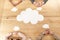 overhead view of multiracial business people at wooden table with blank paper clouds,