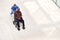 Overhead View Of Nurse Wheeling Male Patient In Wheelchair Through Lobby Of Modern Hospital Building