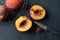 Overhead view of peaches in black wire basket, halved peach, knife