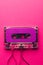 Overhead view of purple cassette tape with copy space on pink background