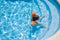 Overhead view of relaxed child with armbands on pool stairs