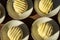 Overhead view of rows of small round lemon cakes covered with striped frosting