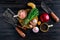 Overhead view of rustic butcher meat knife, cleaver and fork with herbs and spice