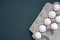 Overhead view of seven white eggs in an open recycled paper container isolated on grey dark blue background.