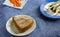 Overhead view of slice of moist,homemade carrot cake,sprinkled with sugar powder on top. Dark Blue background.