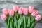 Overhead view of a springtime pink tulips on white weathered wooden boards, top view