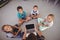 Overhead view of teacher and schoolkids using laptop in library