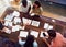 Overhead View Of Team Having Creative Design Meeting Around Wooden Table In Office