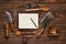 Overhead view of vintage steak fork, knife and hatchet on wooden table next to notebook