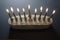 Overhead view of a white and gold Hanukkah menorah with candles lighted