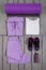 Overhead view woman\'s workout outfit. Female sports equipment. Purple sport pant, shoes, suit, mat, water bottle white