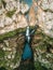 Overhead views waterfall flowing into rock pool at base of cliffs