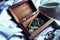 Overhead of wooden jewellery box filled with vintage brooches