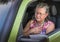 Overheated frustrated senior woman driver with sudden chest pain