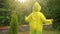 Overjoyed adorable kid raised hands wearing yellow raincoat and dancing, boy having fun under rainfall. Exited child