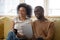 Overjoyed african American couple laugh watching funny video on tablet