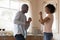 Overjoyed biracial couple have fun dancing in kitchen