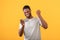 Overjoyed black man celebrating victory with smartphone, won online lottery or game, smiling over yellow background